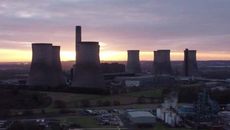 fiddlers ferry disused coal fired power station with sunrise across landmark, aerial descending view