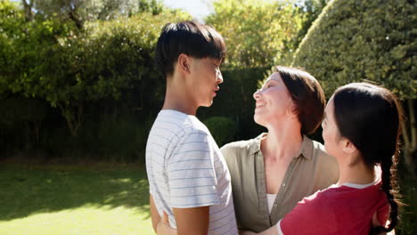 family hugging and smiling together in garden, enjoying outdoor time
