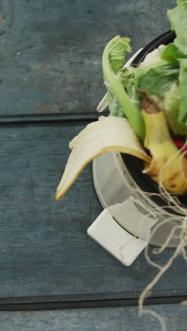 video of white compost bin with organic waste and copy space on grey wooden background