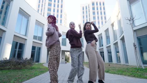 young women dancing modern choreography outdoors