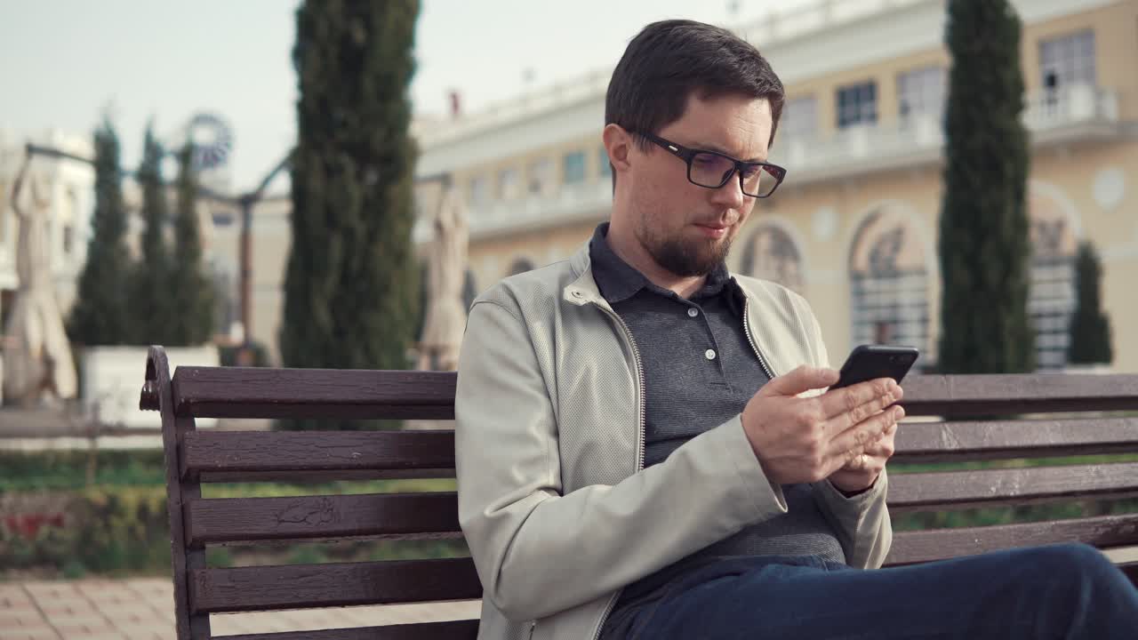 hombre usando un teléfono inteligente en un parque
