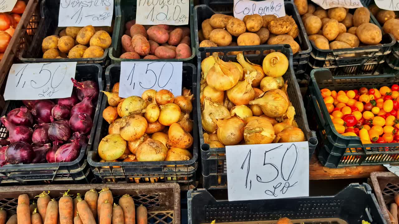 Fresh assorted vegetables at a bustling outdoor market stall