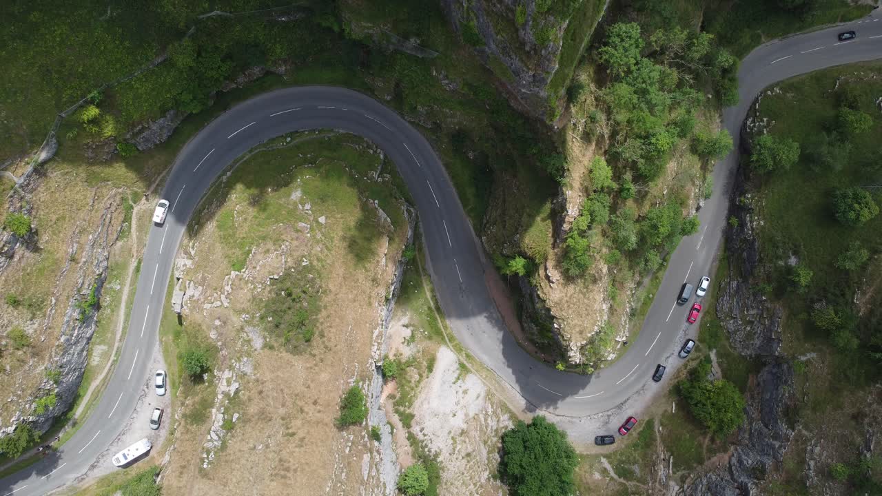 Pull away aerial shot of the road winding through the limestone cliff formations at Cheddar gorge in the Mendip Hills, Somerset, UK