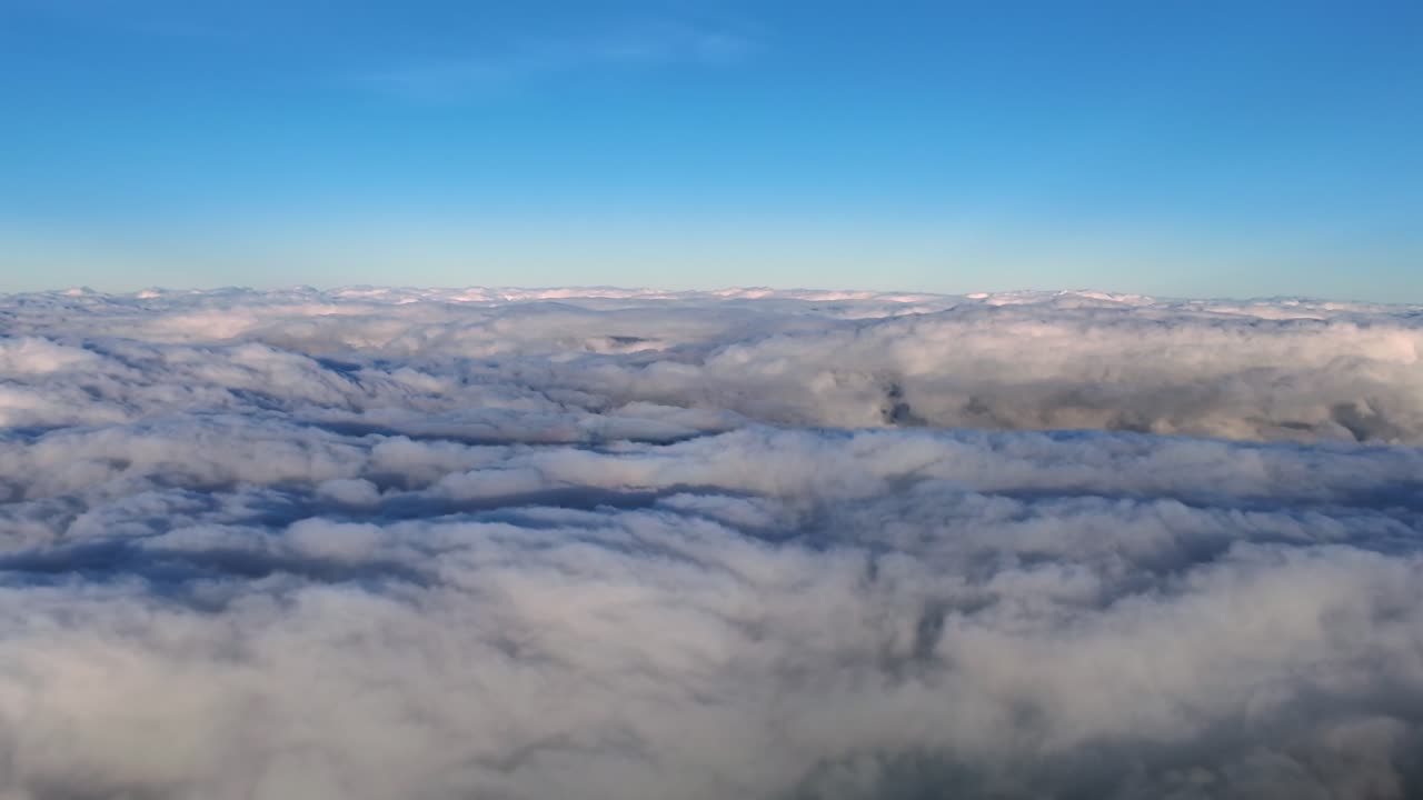 Cockpit view of the halo of a jet airplane on the clouds while flying over an endless sea of stratus clouds under a blue sky