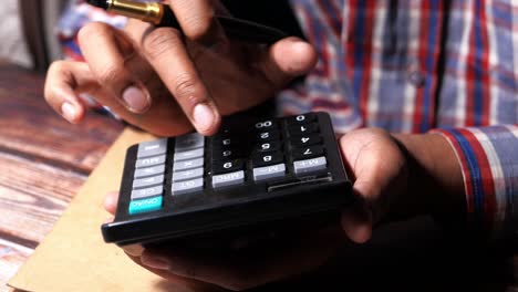 persona que hace cálculos con una calculadora y un bolígrafo