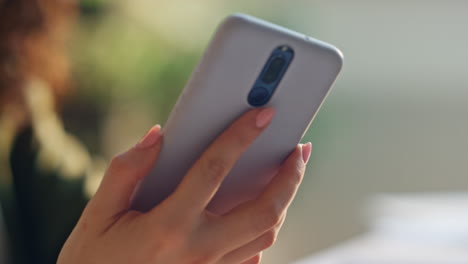 unknown woman taking smartphone lying desk close up. hand holding telephone