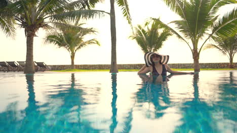 exotic woman in tropical paradise, swimming pool and palm trees in luxury hotel resort