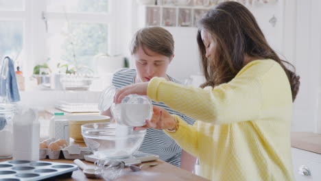 pareja joven con síndrome de down midiendo ingredientes para hornear pastel en la cocina en casa