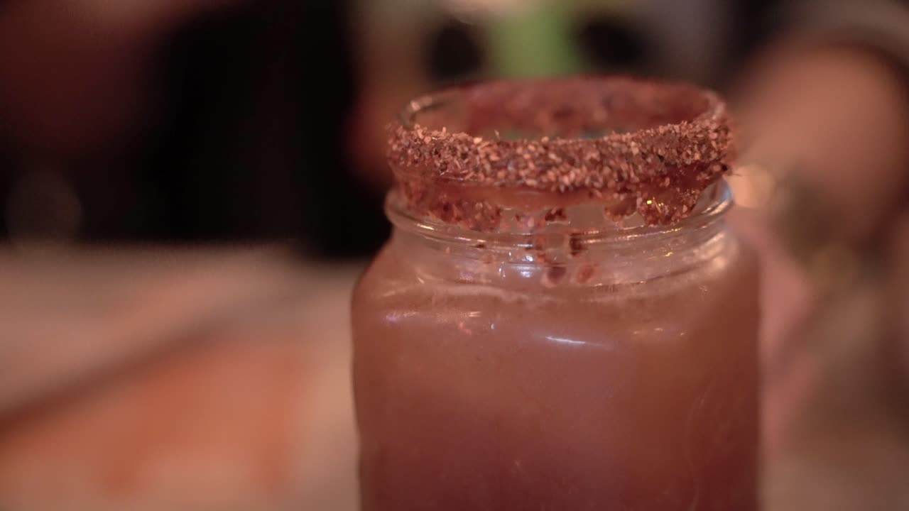 persona agarrando y bebiendo un vaso de alcohol