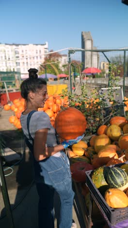 woman picking pumpkins at a fall market