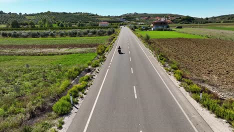 motociclismo en un camino rural cerca de tierras de cultivo