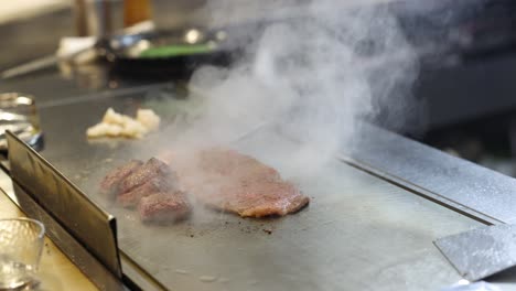 meat searing on a hot teppanyaki grill with flames