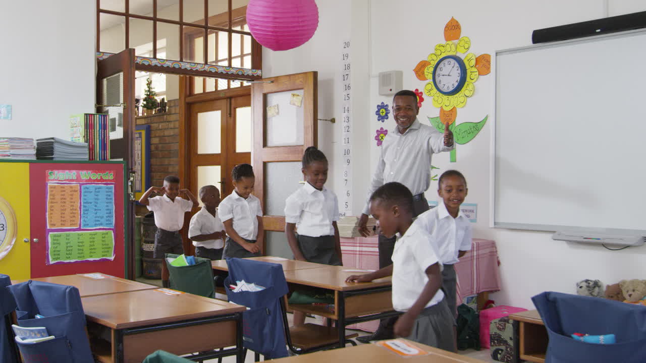 Teacher greets kids arriving at elementary school classroom