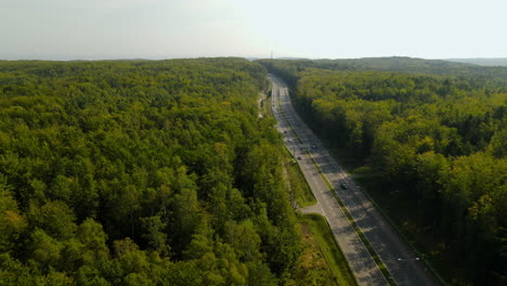 aerial panoramic view of a highway in the middle of a big forest in poland