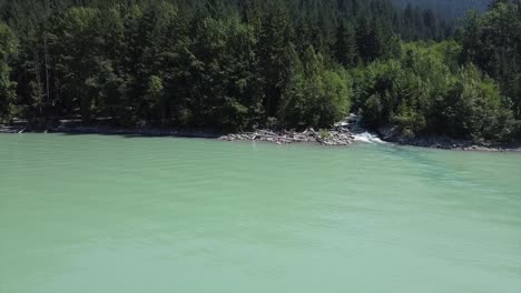 Turistas-En-La-Orilla-Del-Lago-Lillooet-Con-Exuberante-Bosque-De-Coníferas-En-Columbia-Británica,-Canadá