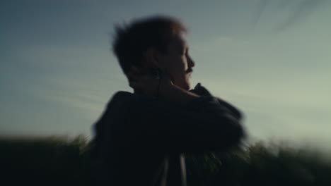 motion-blurred figure in a field against the sky