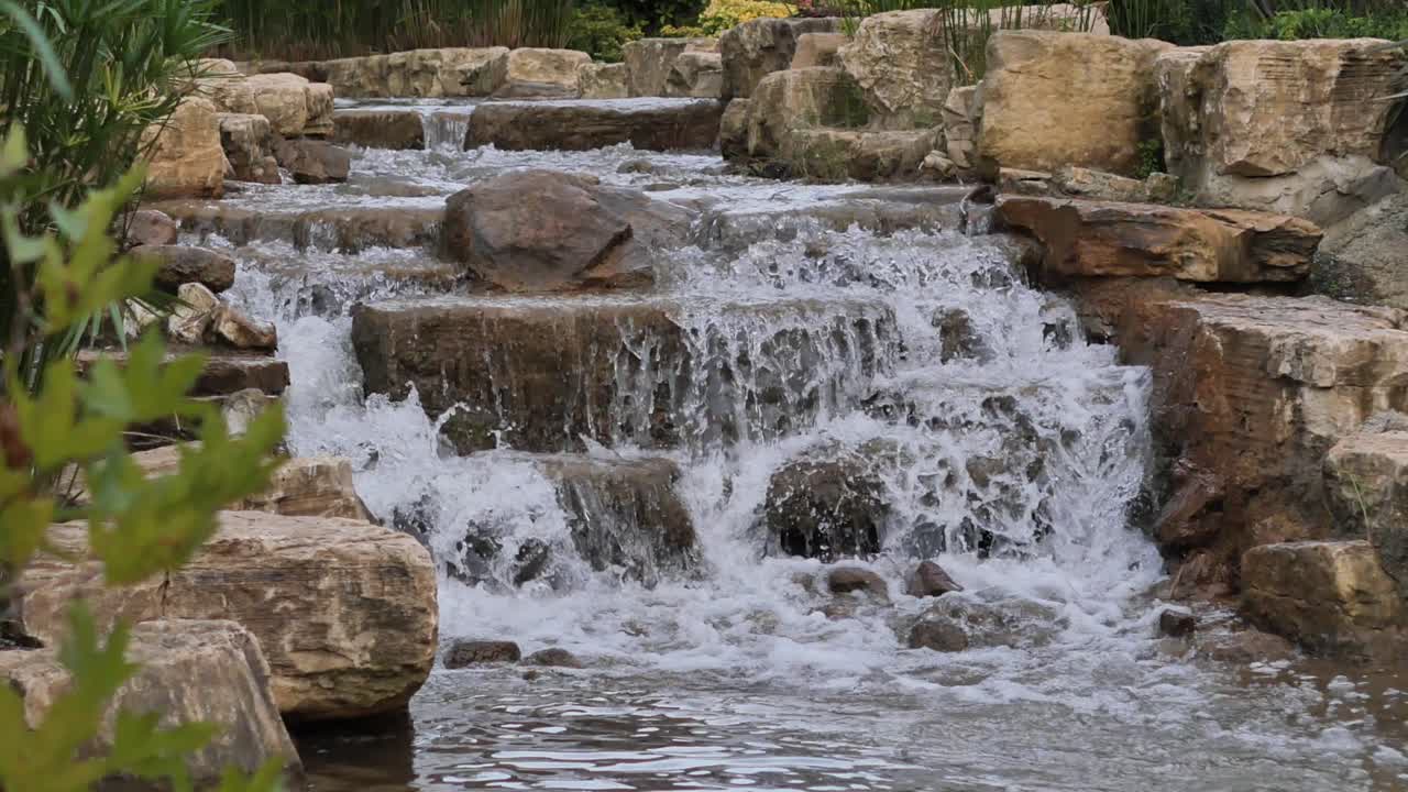 una cascada que fluye sobre las rocas en un jardín
