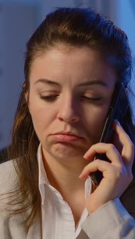 vertical video: concentrated businesswoman during phone call late at night