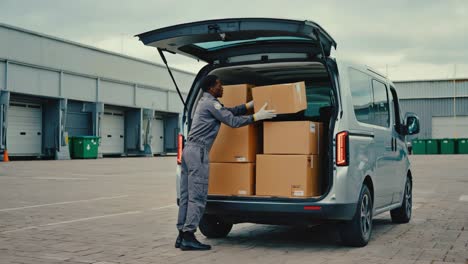 delivery worker loading boxes into a van
