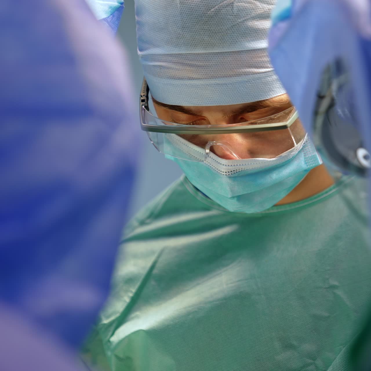 Medico in uniforme, con berretto, mascherina e occhiali protettivi. Dottore che lavora in un'équipe chirurgica.