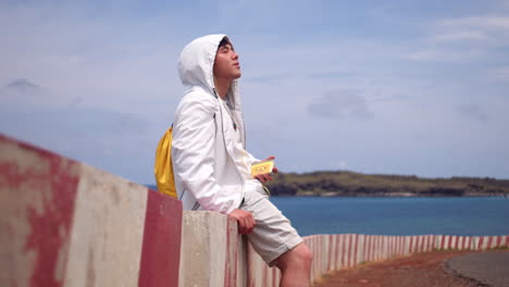 un adolescente escuchando música usando un walkman en la orilla