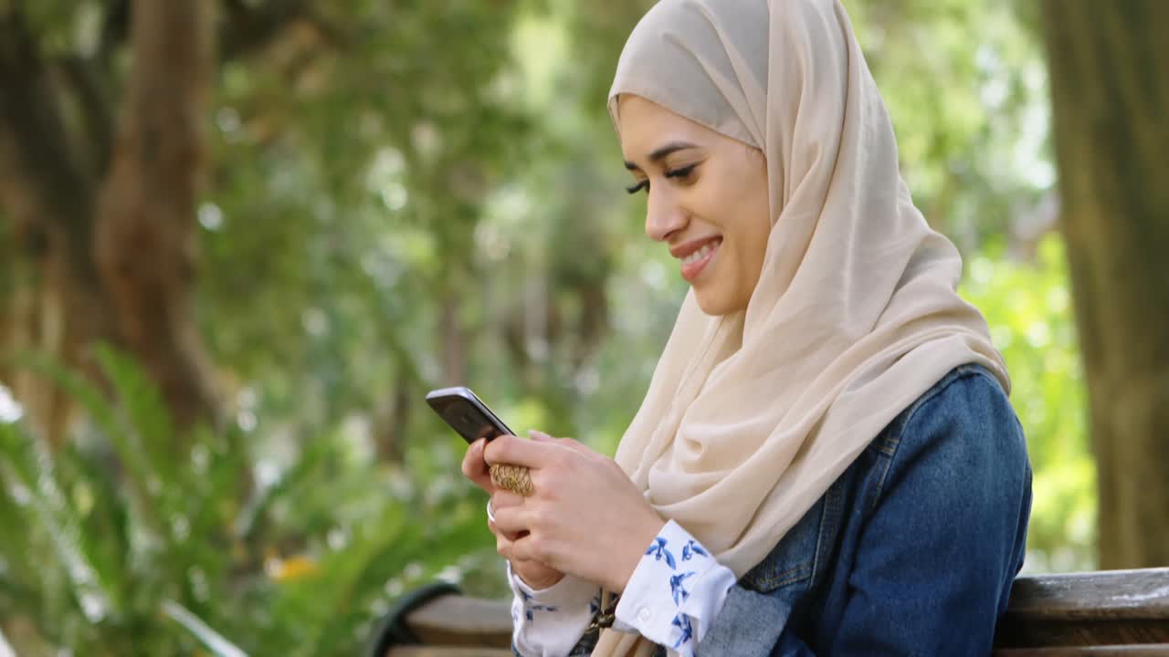 Woman in hijab using mobile phone 4k