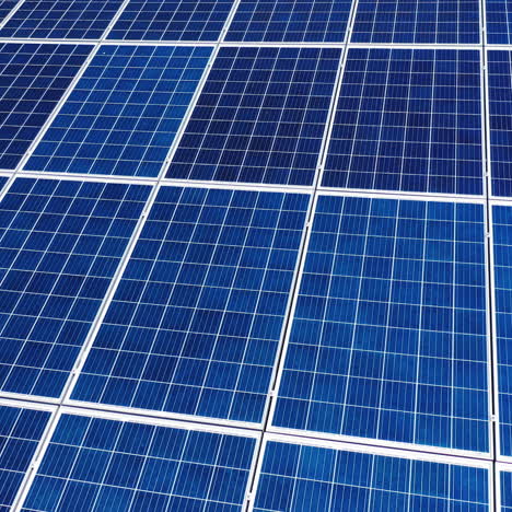 flight over working energy batteries. solar batteries work on a roof to accumulate the sunlight. close-up.