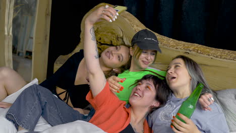 four happy friends taking selfie on the bed