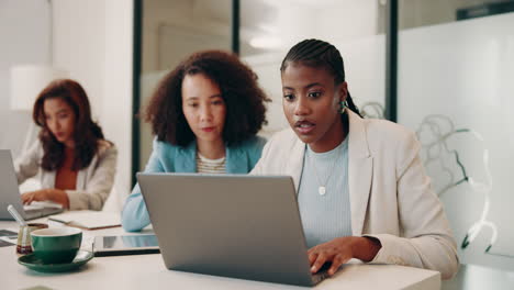 un grupo de mujeres están sentadas en una mesa en un entorno de oficina moderno, teniendo una reunión de negocios.