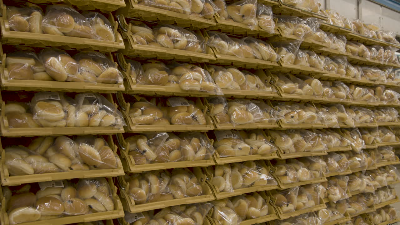A wall of bread buns in plastic sacks