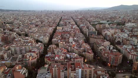 an aerial drone shot of the city center of barcelona featuring catalonia community's new and old buildings