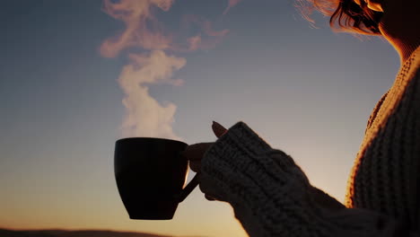woman enjoying coffee at sunrise