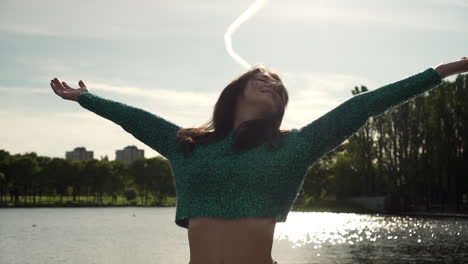 hermosa mujer italiana con los brazos levantados mirando la vista del atardecer sobre el lago