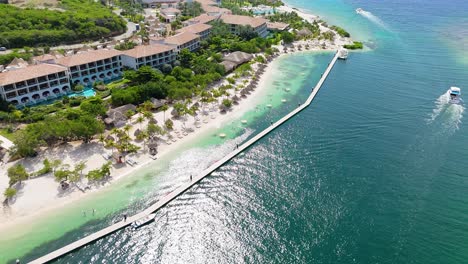 órbita aérea alrededor de sandals beach resort y muelle en un soleado y hermoso día caribeño