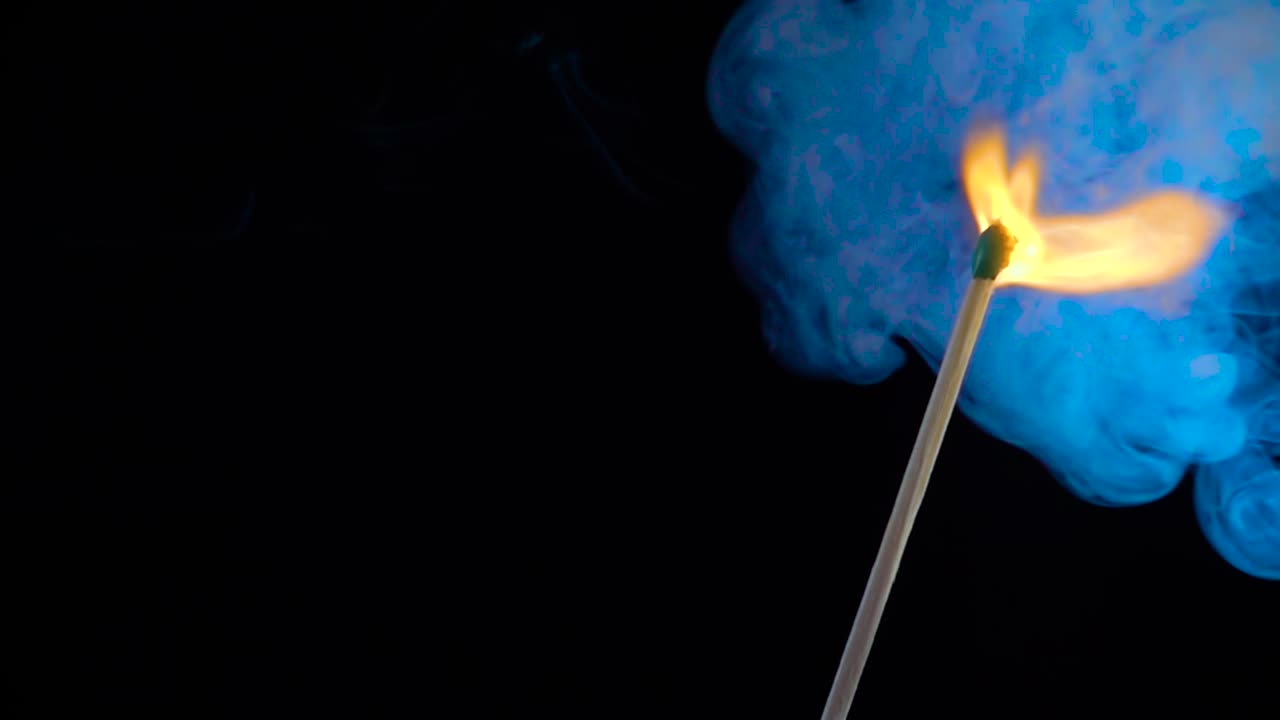 un fósforo ardiendo sobre un fondo negro en cámara lenta