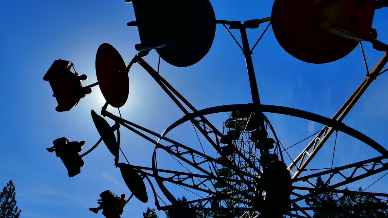 어두운 카루셀 부스는 태양 앞에서 회전하고 있습니다.