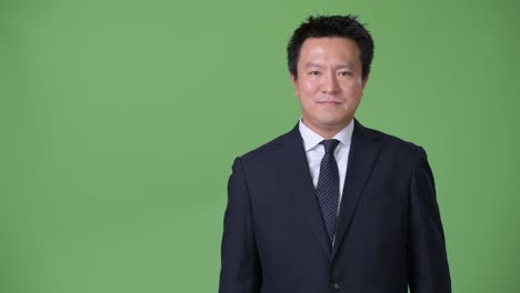 녹색 배경에 성숙한 일본 사업가