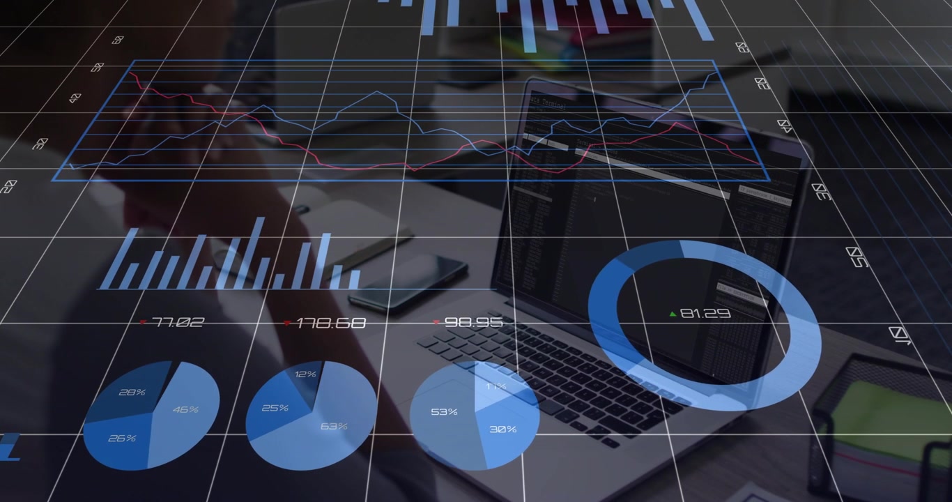 Man sitting at desk watching laptop while live data feed updating and animating charts for business