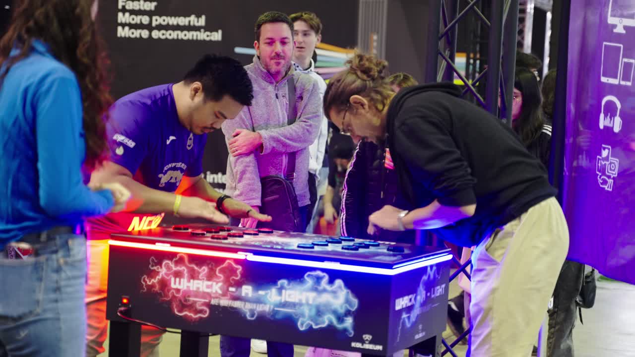 People playing a new game machine smashing big buttons as fast as possible to win having fun and frustration at a convention event at LGX Luxembourg