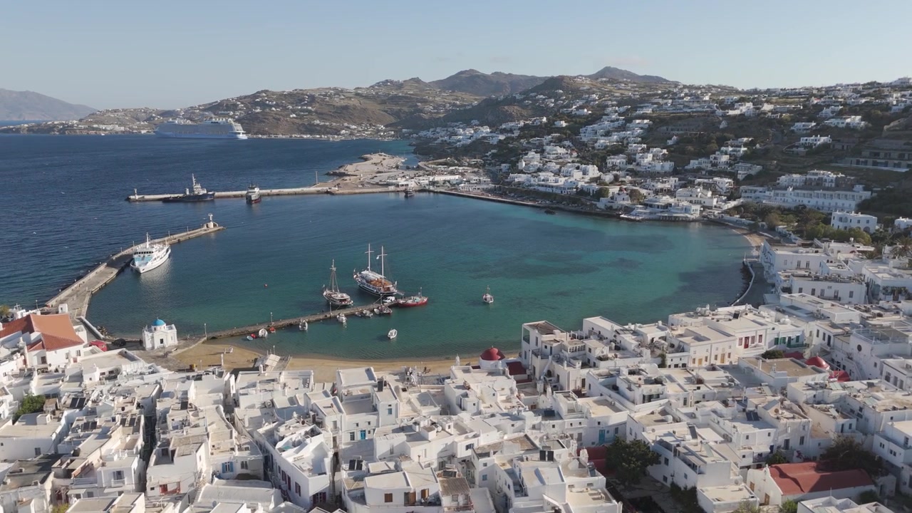 Porto della città di Mykonos con barche e tradizionali case cicladiche bianche che circondano la baia
