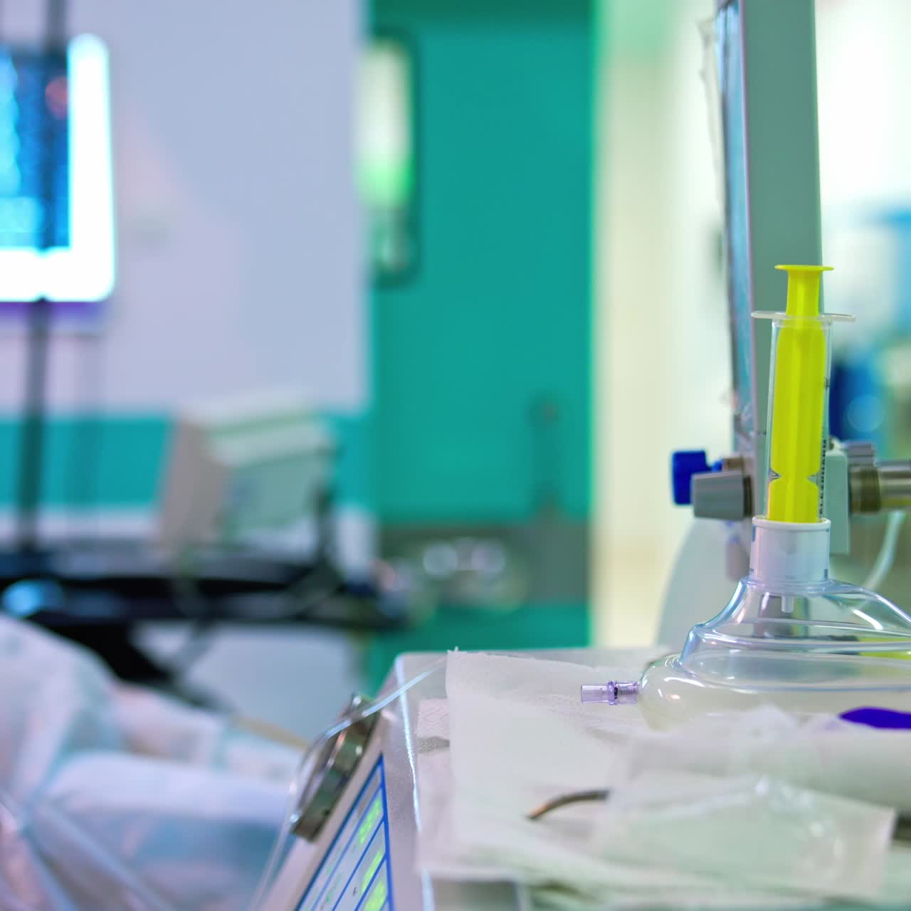 Vybavení na operačním sále během operace. Sestra připravuje nástroje a chystá pacienta na operaci. Rozmazané pozadí.