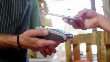 mujer haciendo pago a través de teléfono inteligente