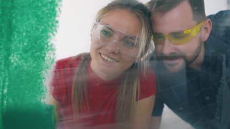 woman-paints-wall-with-green-color-near-boyfriend-in-room