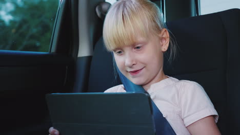 Fun On The Road The Girl Uses A Tablet Rides In The Back Seat Of The Car 4k Video