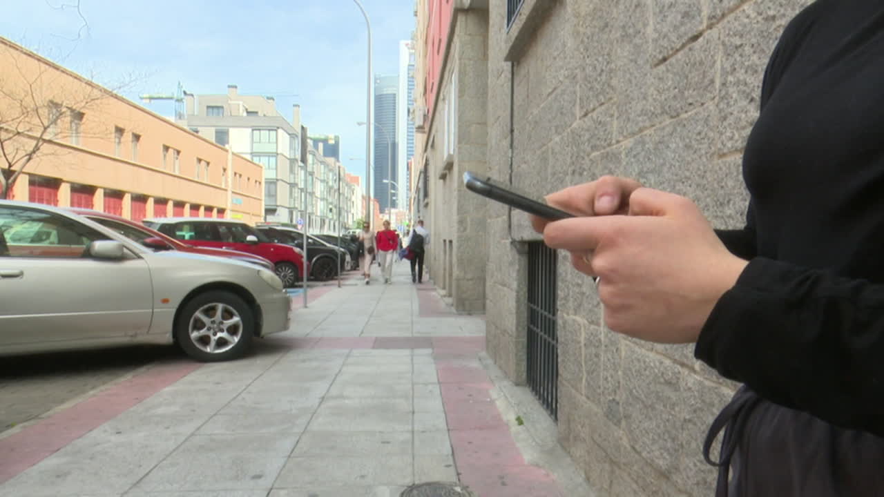 persona que utiliza un teléfono inteligente en una calle de la ciudad