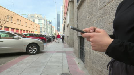 persoon die een smartphone gebruikt op een stadsstraat