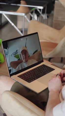 - hombre vertical usar portátil para hacer llamadas de video, ajustar el brillo de la pantalla