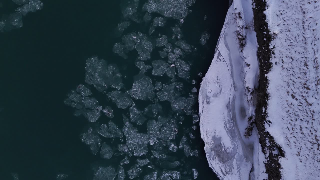 Drifting Ice Over Tranquil River In Selfoss, South Iceland. Aerial Topdown Shot