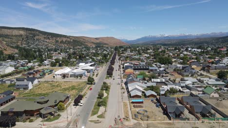 Dolly-Volando-Sobre-La-Calle-Principal-De-La-Ciudad-De-Esquel-Con-Montañas-Andinas-De-Fondo,-Patagonia-Argentina