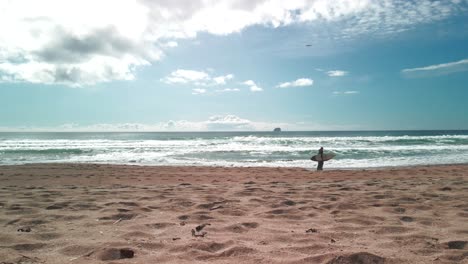 Two-surfers-walking-along-the-beach